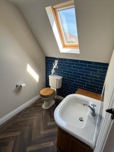 a bathroom with a toilet and a sink and a window at Fallow View - Luxury Countryside Cottage in Coughton +11 photos