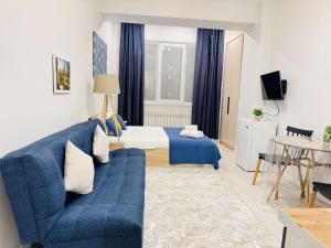 a living room with a blue couch and a bed at 417I1 Gray and Yellow apartment Sholpan city in Almaty