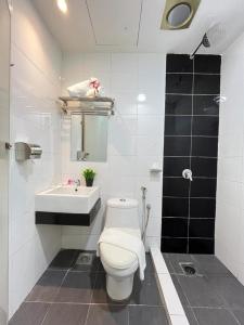 a white bathroom with a toilet and a sink at AQ Hotel Kuala Lumpur in Kuala Lumpur