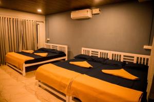 two beds in a room with yellow pillows on them at River view adventures in Dandeli