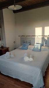 a bedroom with a white bed with towels on it at Domo Gallus Zola in Galtellì