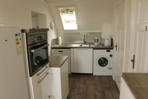 a small kitchen with a sink and a washing machine at Storchennest in Kuden