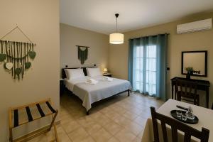 a bedroom with a white bed and a table and a window at Nicolas Beach in Palaiochora