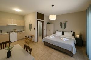a bedroom with a large bed and a kitchen at Nicolas Beach in Palaiochora