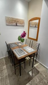 a dining room table with a vase of flowers on it at Katerina s House 1 in Nydri +16 photos