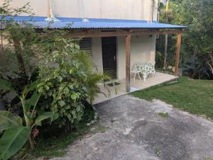 a house with a table and chairs on a porch at Appartement Labrousse - POM KANEL in Le Gosier