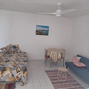 a room with a bed and a table and a couch at Appartement Labrousse - POM KANEL in Le Gosier