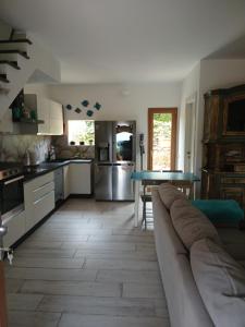 a living room with a couch and a kitchen at Ottiolu House villa 50m from beach in Porto Ottiolu