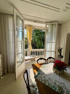 a dining room with a table and a large window at Lilac Luxury Apartment in Lido