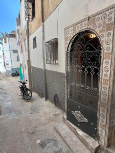 a door to a building with a motorcycle parked next to it at Taghazout Gem - 2BR, Fast Wi-Fi in Agadir