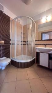 a bathroom with a shower and a toilet and a sink at Dom Studencki Zbyszko in Poznań +12 photos