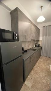 a kitchen with a black refrigerator and a sink at Katerina s House 1 in Nydri