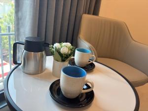 a table with two coffee cups and flowers on it at Vijay Vilas Hotel in Jālna
