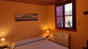 a bedroom with a bed and a window at Tenuta Soria Location immersa nel verde con piscina privata in Frassino