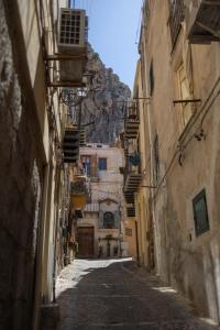 an alley in an old town with a mountain at Dalì alla rocca in Cefalù