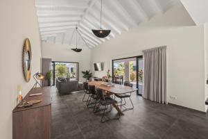 a dining room and living room with a table and chairs at Villa Jasmijn, Mambo Beach, Private Pool in Willemstad