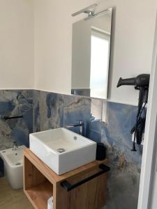 Un baño con un lavabo blanco y un espejo. en MARE Suite, en Palermo