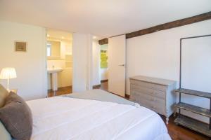a bedroom with a white bed and a dresser at Cal badia in Vilallovent