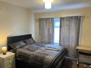 ein Schlafzimmer mit einem Bett und einem Fenster in der Unterkunft Five Oaks House- Entire 3 Bedroom House for Family & Contractors with up to 5 sleep- NO PARTIES ALLOWED in Willenhall
