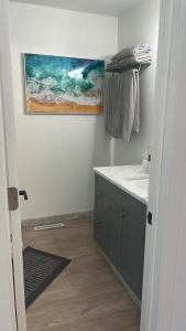 bagno con lavandino e dipinto sul muro di Bosco Bluff Cottage a Lansing