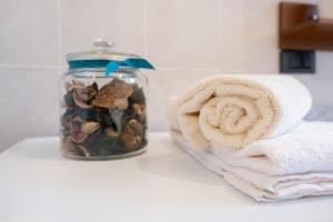 un frasco de vidrio lleno de piedras y una toalla en Appartamento Margherita, en Porto Valtravaglia 17 fotos más
