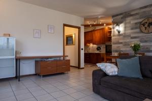 Una sala de estar con un sofá y una cocina. en Appartamento Margherita, en Porto Valtravaglia