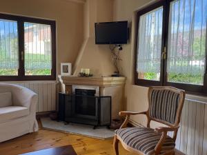 a living room with a fireplace and a tv at Casa de Robles Cantabria, en el corazón de los Valles Pasiegos in Sel de la Carrera