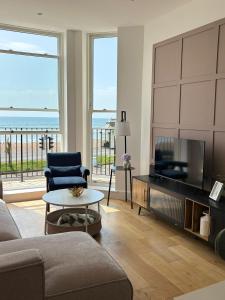 un soggiorno con TV, divano e tavolo di Stunning 3 Bed Apartment with Seaview a Worthing