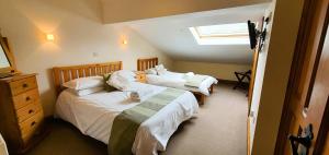 a bedroom with two beds and a window at The Victorian Barn, Self-Catering Holidays with Pool and Hot Tubs, Dorset in Woolland +218 photos