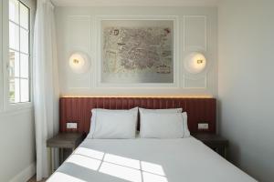 a bedroom with a large bed with two pillows at Exe Zarzuela Park in Madrid