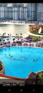 a large swimming pool with people in the water at The Beverly-BE2-Vinhomes Grand Park in Gò Công