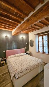 a bedroom with a large bed with a pink headboard at Casa Paola nel Chianti in Castelnuovo Berardenga