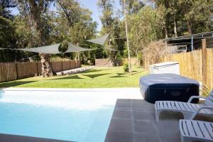 a swimming pool with two chairs and a blue ottoman at Destino Fortín in Villa Argentina