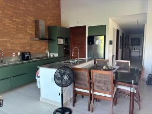 a kitchen with green cabinets and a table with chairs at Casa da praia in Parnamirim +8 photos