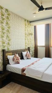 a bedroom with a bed with white sheets and pillows at Hotel AMOUR in Zirakpur