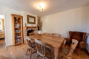 ein Esszimmer mit einem Holztisch und Stühlen in der Unterkunft The Cottage - Holiday home in Reedham on the Southern Norfolk Broads in Reedham