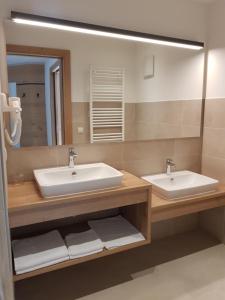 a bathroom with two sinks and a large mirror at Hotel Restaurant Schaurhof in Vipiteno