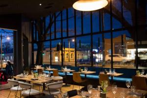 ein Restaurant mit Tischen und Stühlen und einem großen Fenster in der Unterkunft Prime Luxury Penthouse Living in Launceston