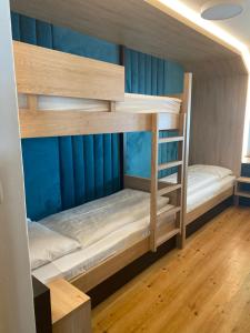 two bunk beds in a room with blue walls at Hotel Restaurant Schaurhof in Vipiteno