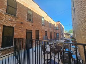 an apartment balcony with chairs and a brick building at Albany Merchants Hotel in Albany
