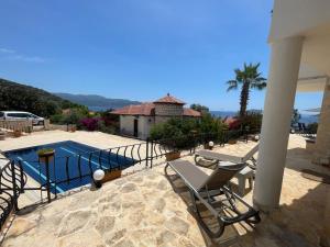a patio with two chairs and a swimming pool at Monix Homes-Villa Magic Garden in Kaş