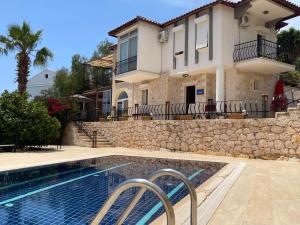 a house with a swimming pool in front of a house at Monix Homes-Villa Magic Garden in Kaş