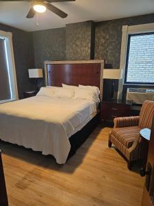 a bedroom with a large bed and a chair at Albany Merchants Hotel in Albany +49 photos
