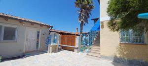 a house with a gate and a palm tree at Buena Vista in SantʼAntìoco