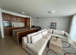 a living room with a couch and a kitchen at Hotel Du Quai in Villeneuve