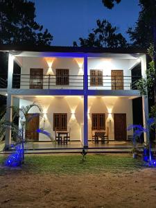a white house with lights in the night at Royal Breeze Resort Sigiriya in Sigiriya