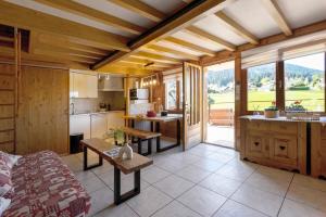 a kitchen and living room with a couch and a table at Chalet Pagotin in Métabief