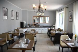 a restaurant with tables and chairs and a kitchen at D&D Hotel by Wiggers in Bad Oldesloe