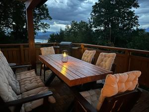 a wooden table and chairs on a deck at Villa Sara - Wörtherseeblick, Skifahren, Sauna in Sankt Bartlmä