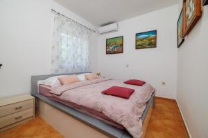 a bedroom with a bed with red pillows on it at Dana in Grižane +46 photos